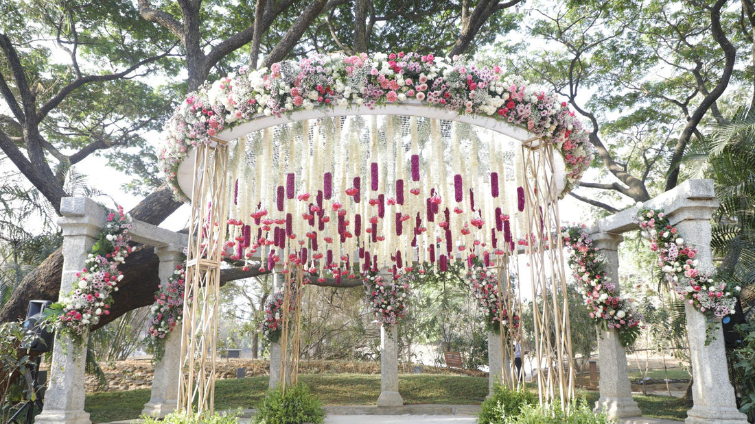 Elegant floral mantap adorned with pink, white, and violet blooms, perfect for weddings and outdoor ceremonies. Stunning decor for unforgettable events.