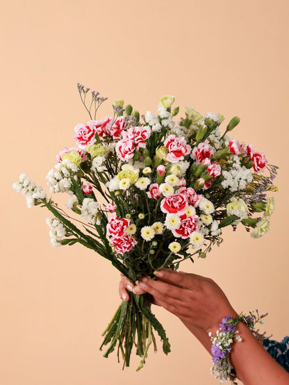 Hand offering a beautiful bouquet of fresh flowers, perfect for a gift or special occasion